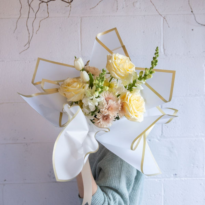 Bouquet of flowers with a geometric gold frame on a white background